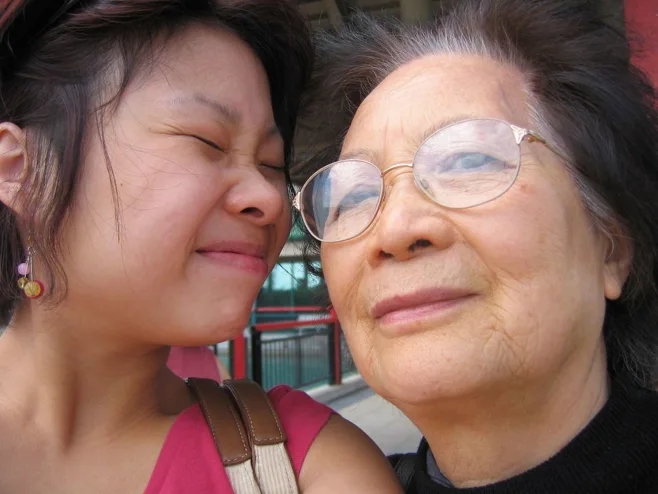 Daughter squinting and smiling at mother Daughter squinting and smiling at mother